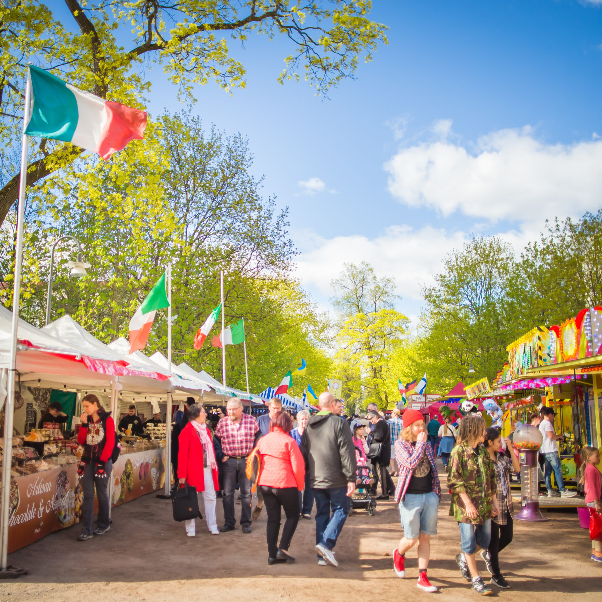 Kansainvälisen ruokatorin värikkäitä kojuja ja asiakkaita Hämeenpuistossa.