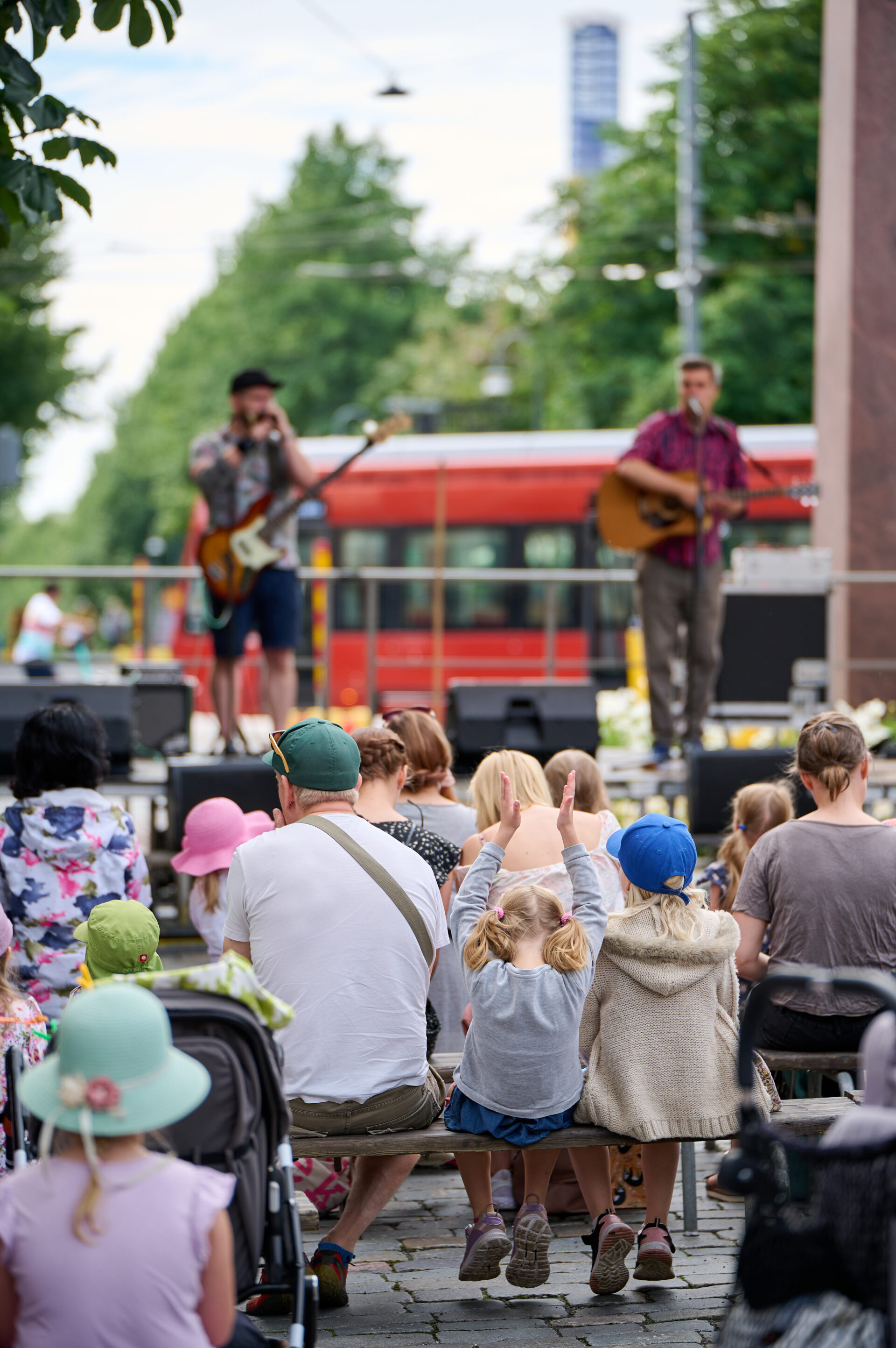 Perhe katselemassa esiintymislavalla Hämeenpuiston Puistofiesta -tapahtumassa.