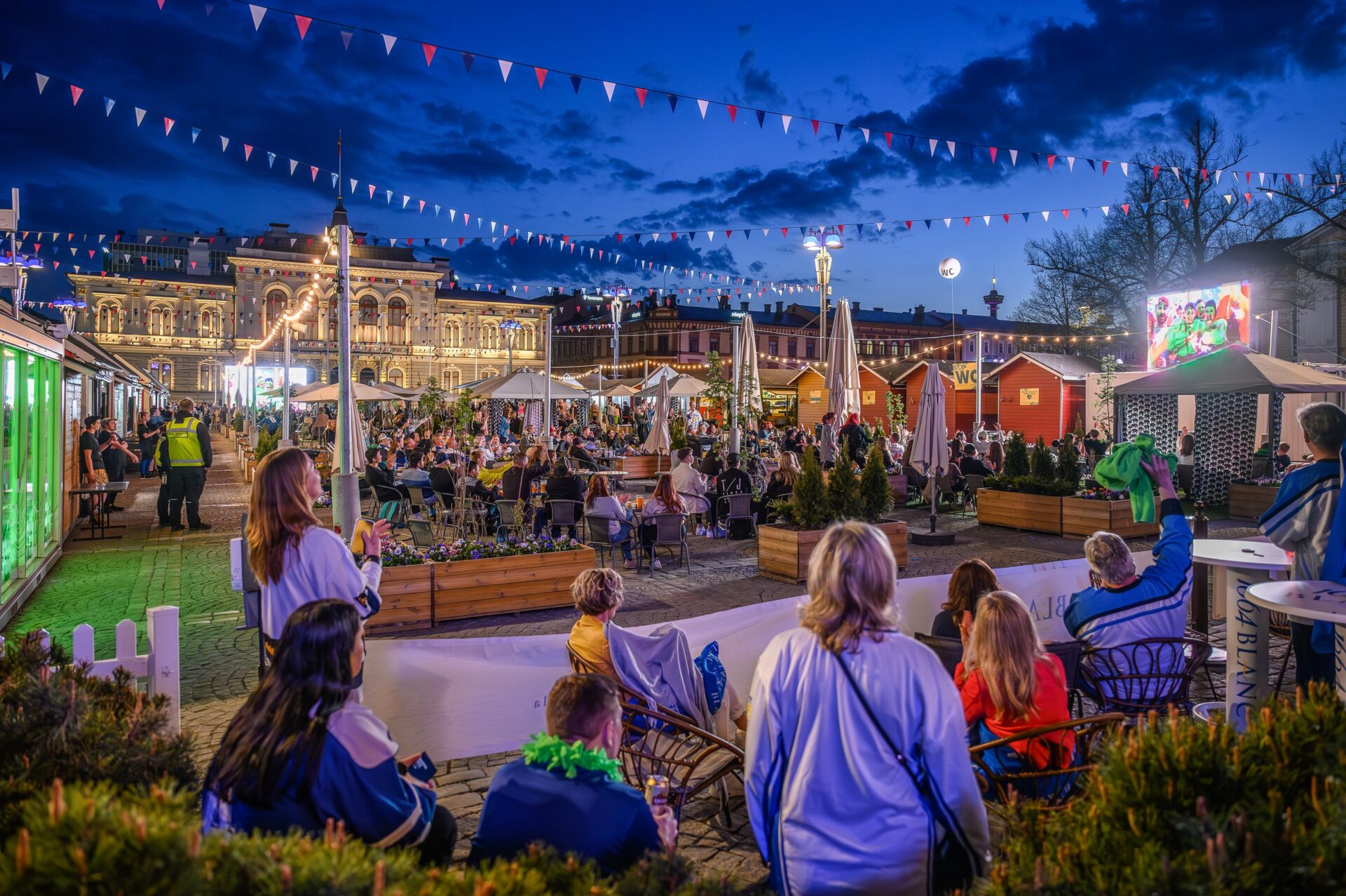 Yleisöä katsomassa jääkiekon MM-kisojen lähetystä Keskustorin Kesäkeitaalla.