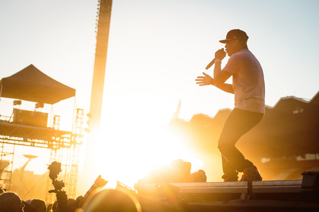 Artisti esiintymislavalla auringon laskiessa taustalla.