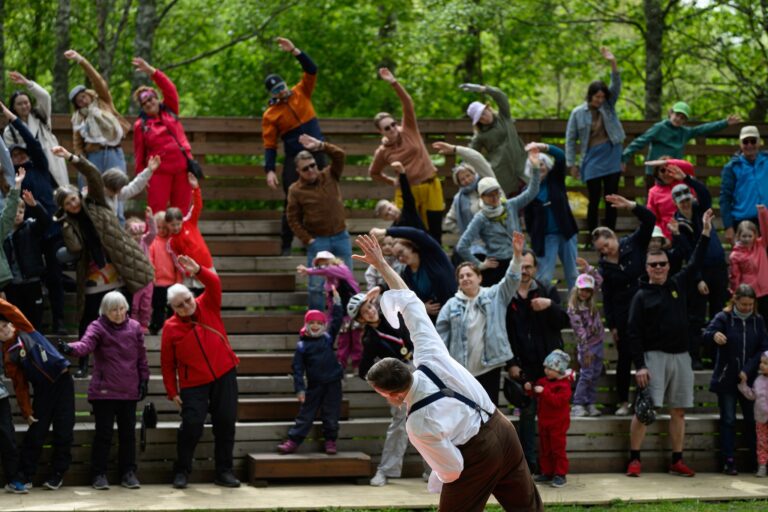 Esiintyjä vetää katsomossa olevalle yleisölle jumppaa.